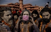 A 'Naga Sadhu,' or Hindu holy man, places a mask across his face before entering the Ganges river during the traditional Shahi Snan, or royal dip, at the Kumbh Mela festival in Haridwar, India, Apr 12, 2021. REUTERS/Danish Siddiqui